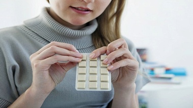 Young woman holding a pack of nicotine gum.