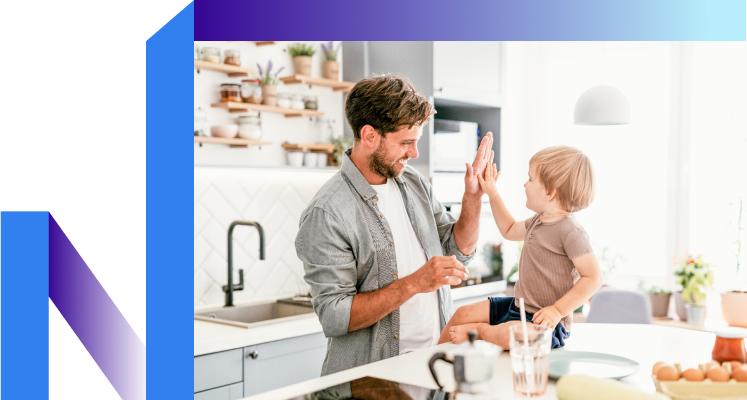A man and a child joyfully high-five in a bright kitchen, celebrating their connection.