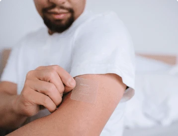 a man placing a smoking cessation patch on his arm