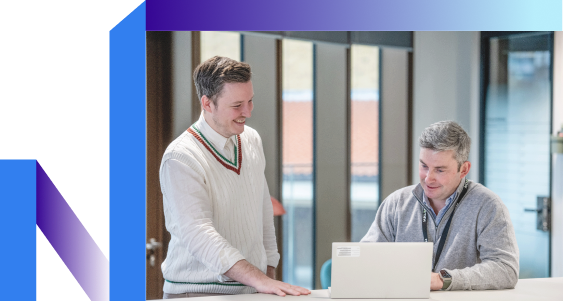 A man showing his laptop screen to his colleague