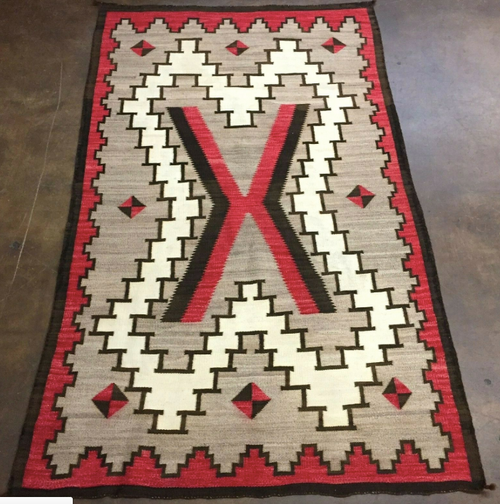 Ganado style rug with red, brown, creams.