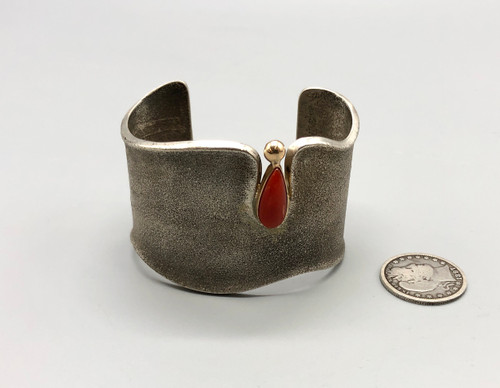 sterling silver, gold, and coral bracelet by award winning artist Edison Cummings, coral tear drop shaped cabochon in a gold bezel