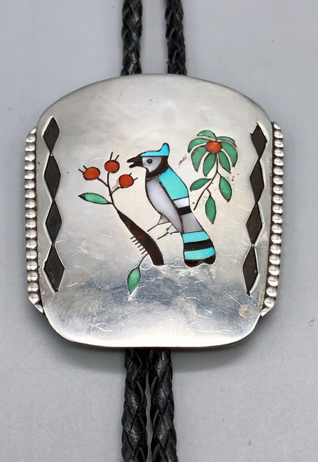 circa 1960s-1970s multi-stone inlay bolo tie, turquoise, mother of pearl, coral, deep silver cut outs, braided black leather cord