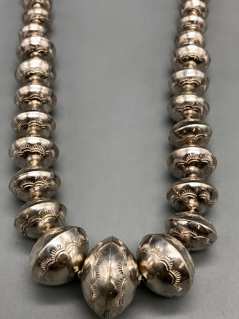 a stamped sterling silver bead necklace, medium length, strung on a silver chain