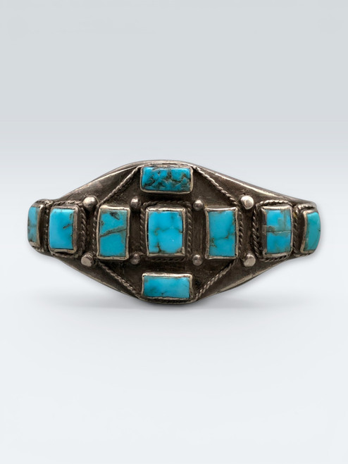 Nine old natural rectangular cut turquoise cabochons in handmade bezels, accented with twisted wire and silver dots
