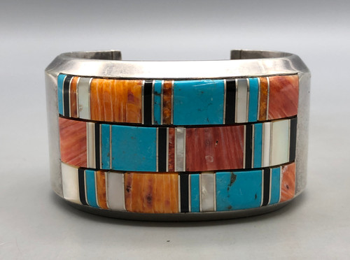 three distinct and beautiful rows of flush channel inlay featuring varying shades of shiny oyster, onyx, mother of pearl and turquoise