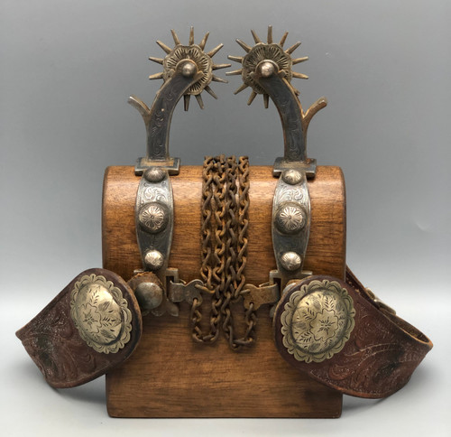fancy California style spurs, leather spur straps, single mounted, iron work, 14 point rowels, turned down shanks, chap guards, engraved silver buttons, incised silver, original heel chains,