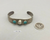A Fred Harvey era cuff, with two turquoise cabochons and fluted silver drop.