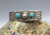 A Fred Harvey era cuff, with two turquoise cabochons and fluted silver drop.