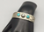 A Fred Harvey era cuff, with two turquoise cabochons and fluted silver drop.