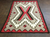 Ganado style rug with red, brown, creams.