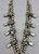 unique squash blossom necklace set with a matching ring, great turquoise nugget cabochons throughout the naja and blossoms, silver applique