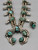 unique squash blossom necklace set with a matching ring, great turquoise nugget cabochons throughout the naja and blossoms, silver applique
