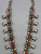 vintage sandcast coral squash blossom necklace, singular coral cabochon,  sterling silver and is strung on a foxtail wire for durability