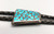 turquoise fish scale bolo tie, inlay design on the slide with smooth silver along the edges, black leather cord