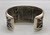 tufa cast and cobblestone inlay bracelet by Navajo artist, Harrison Jim, cobblestone inlay of wood, turquoise, onyx, and coral, geometric designs