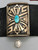 thick silver plate with a single gorgeous turquoise cabochon, lovely geometric overlay with a stippled, darkened background