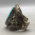 larger central turquoise stone, hand stamped designs, filework, twisted wire, silver dots, and silver applique