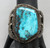 larger central turquoise stone, hand stamped designs, filework, twisted wire, silver dots, and silver applique