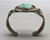 central turquoise cabochon, filework, darkened silver background, three wire terminal