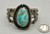 central turquoise cabochon, filework, darkened silver background, three wire terminal