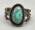 central turquoise cabochon, filework, darkened silver background, three wire terminal