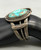 central turquoise cabochon, filework, darkened silver background, three wire terminal