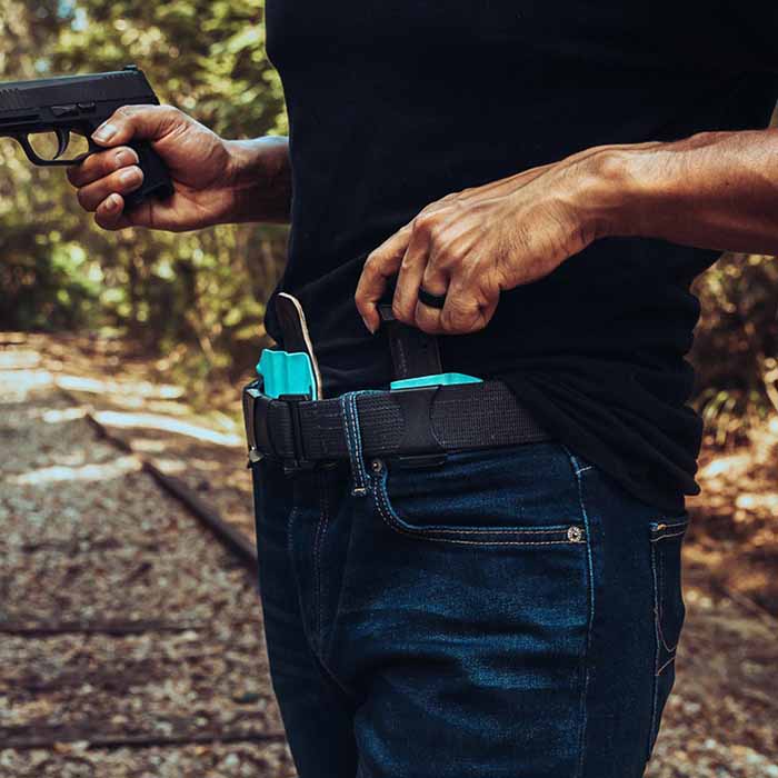 Man reaching to draw a magazine from the MagTuck holster.