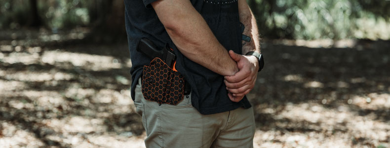 Guy on the outdoors carrying his firearm in a LightDraw OWB Holster from Vedder Holsters.