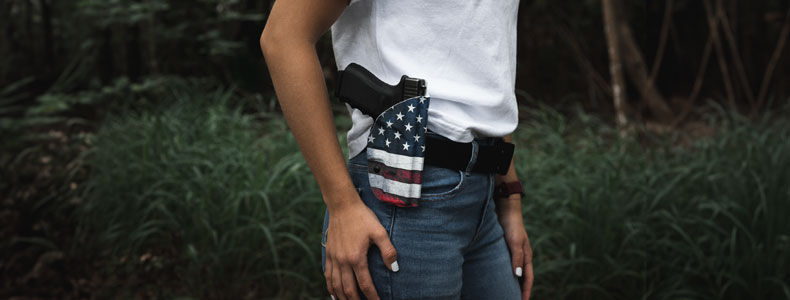 Woman on the outdoors carrying her handgun on a ProDraw OWB Holster from Vedder Holsters.