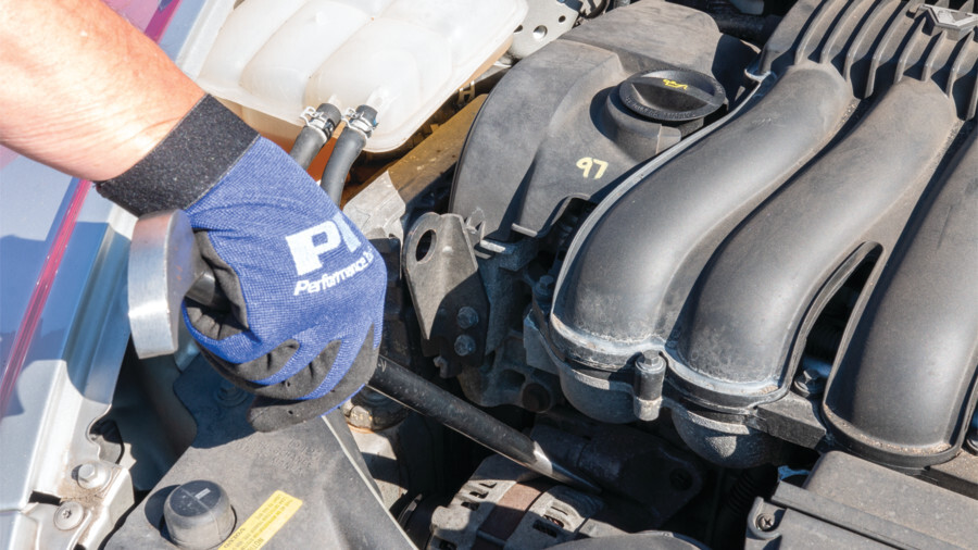 Performance Tool pry bars featuring a pry bar being used underneath an engine under the hood