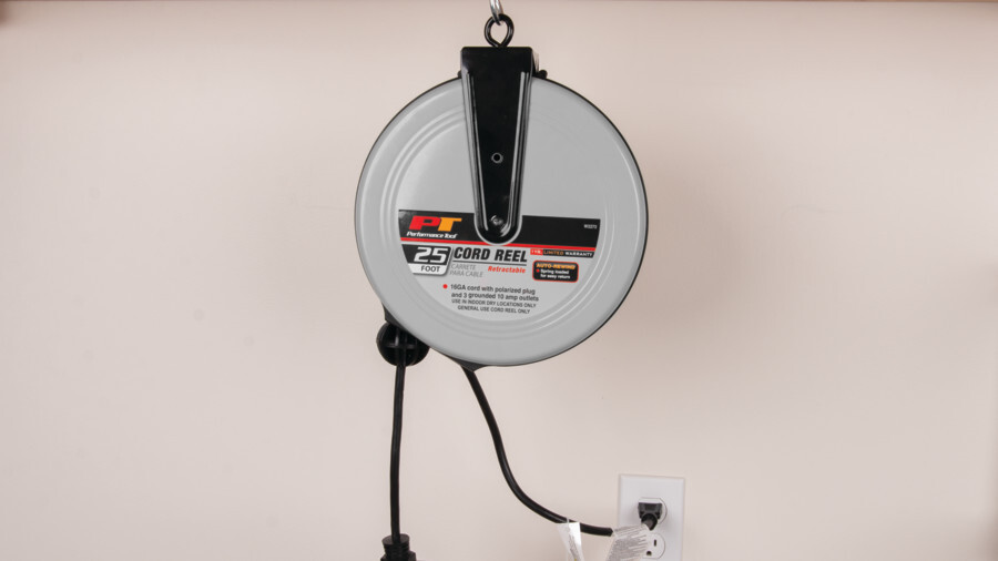Performance Tool cord reels, featuring an image of a 25 foot cord reel hanging from a hook in the wall plugged into an outlet