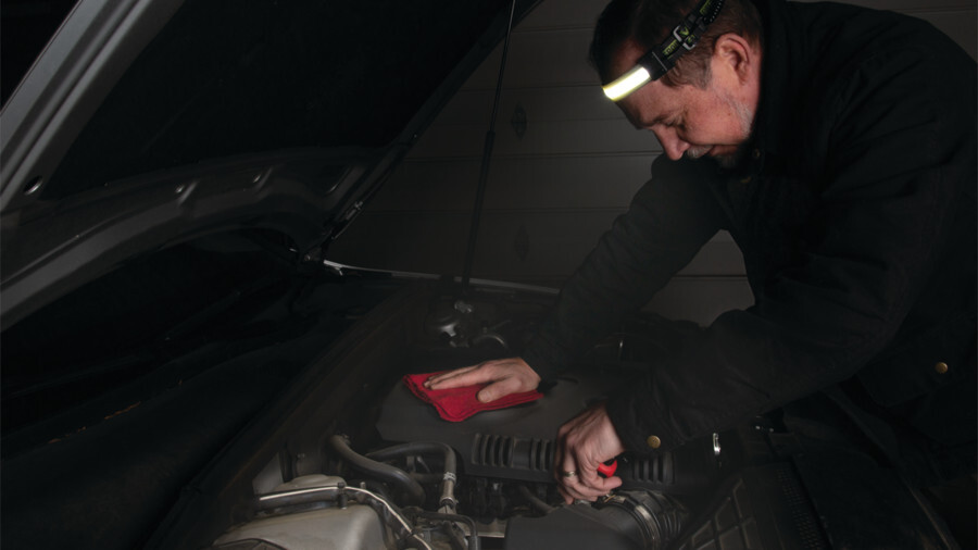 Performance Tool headlamps featuring an image of a man working under the hood of his car at night wearing a headlamp