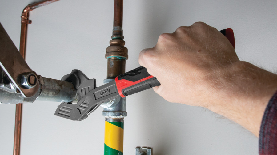 Performance Tool adjustable wrenches, featuring an image of a universal adjustable wrench working on a pipe