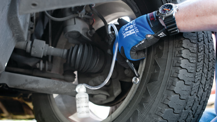 Performance Tool brake bleeding tools, featuring a brake bleeder working on a brake caliper under a vehicle.