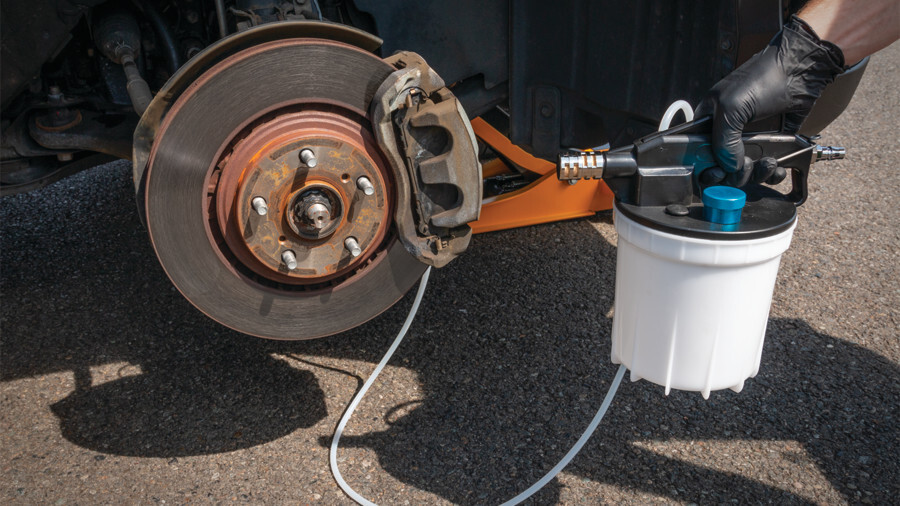 Performance Tool Brake Service Tools, featuring a pneumatic brake bleeder attached to a brake caliper.