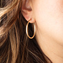 14K Yellow Gold Textured Cut Hoop Reversible Earrings on female model