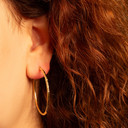 Yellow Gold Diamond Cut Tube Hoop Earrings on female model