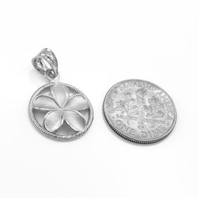.925 Sterling Silver Hawaiian Plumeria Flower Circle Rope Pendant next to a quarter
