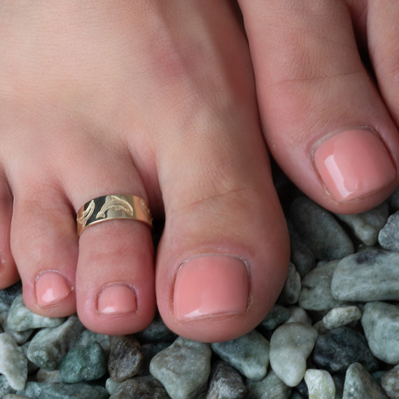 Gold Woman's Chic Dolphin-Inspired Toe Ring on female model