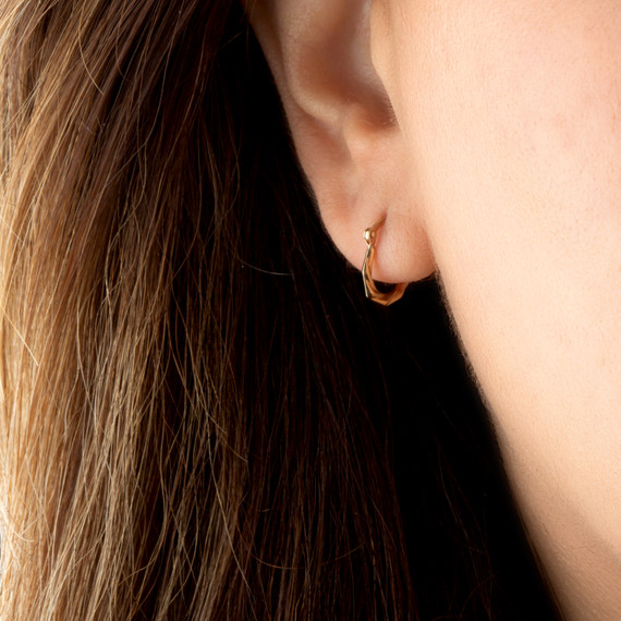 14K Yellow Gold Reversible Diamond Cut Twist Hoop Earrings on female model