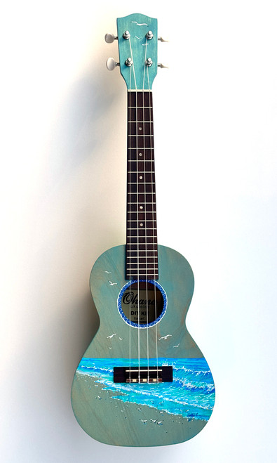 Hand‑painted Ohana CK Kit concert ukulele with a coastal ocean scene, light blue body, dark fretboard, and professional setup for display or playing.