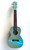 Hand‑painted Ohana CK Kit concert ukulele with a coastal ocean scene, light blue body, dark fretboard, and professional setup for display or playing.
