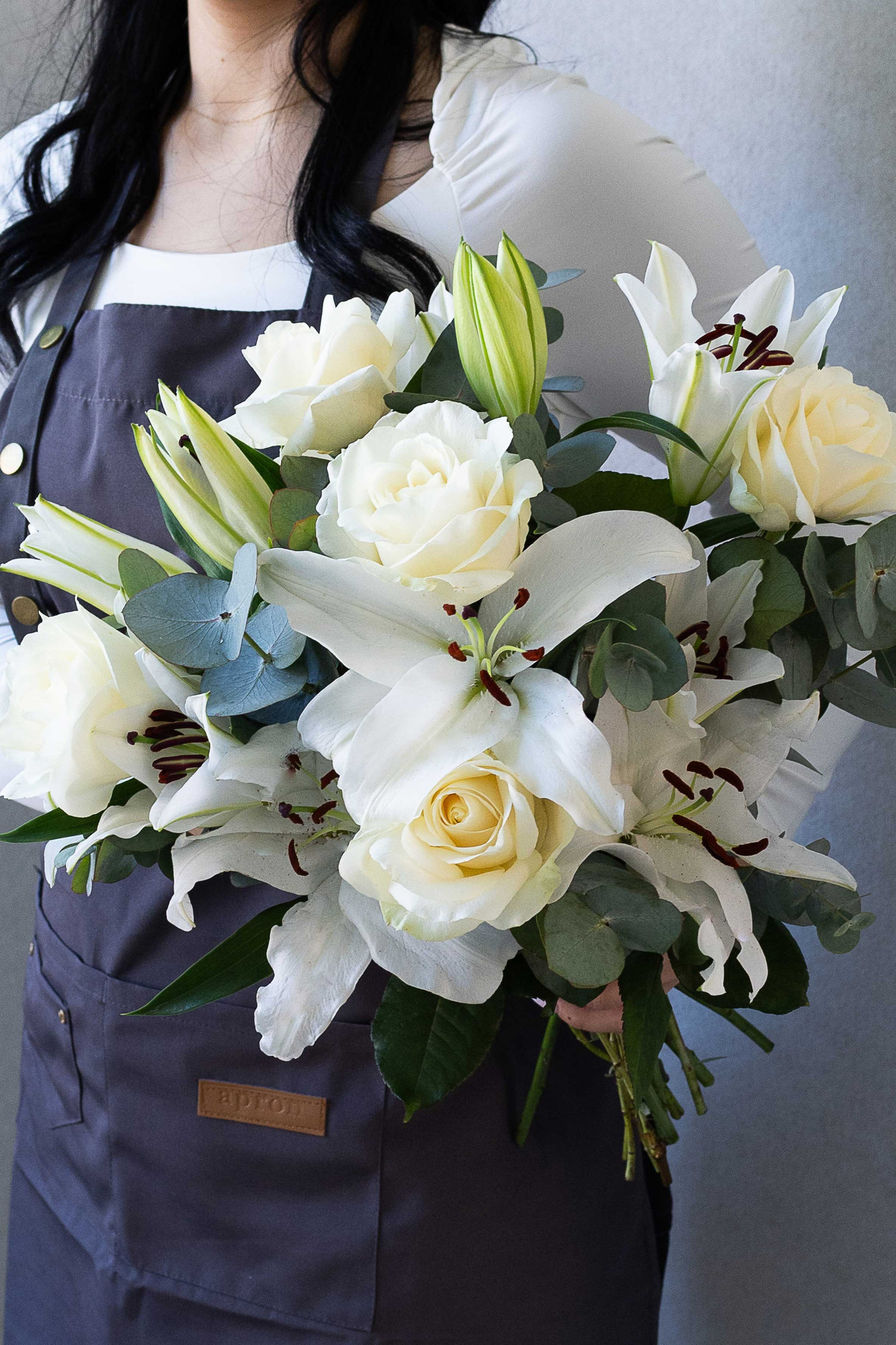 White lily and ivory rose bouquet with eucalyptus greenery.