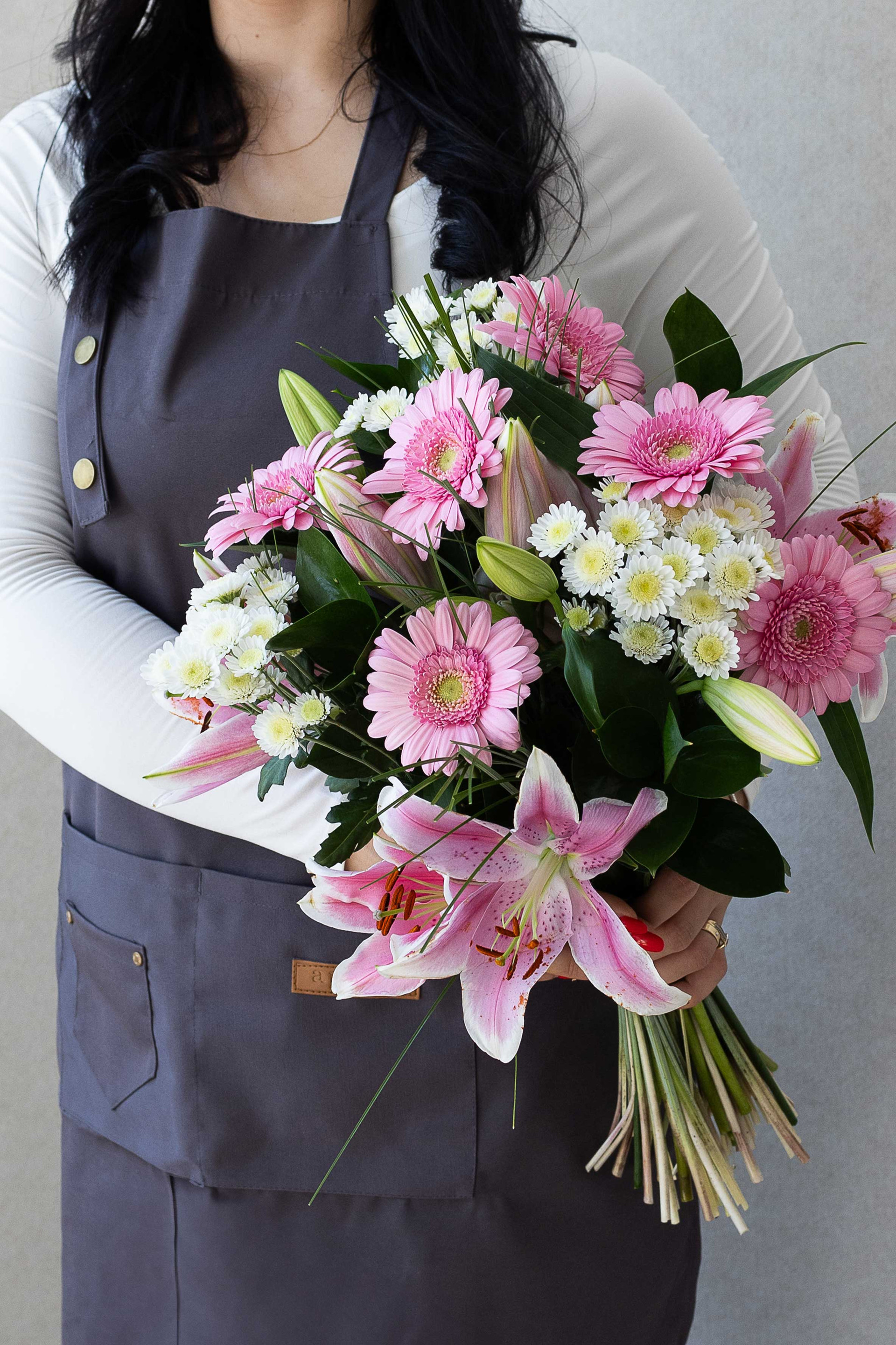 Elegant bouquet of pink lilies, gerberas and white blooms.