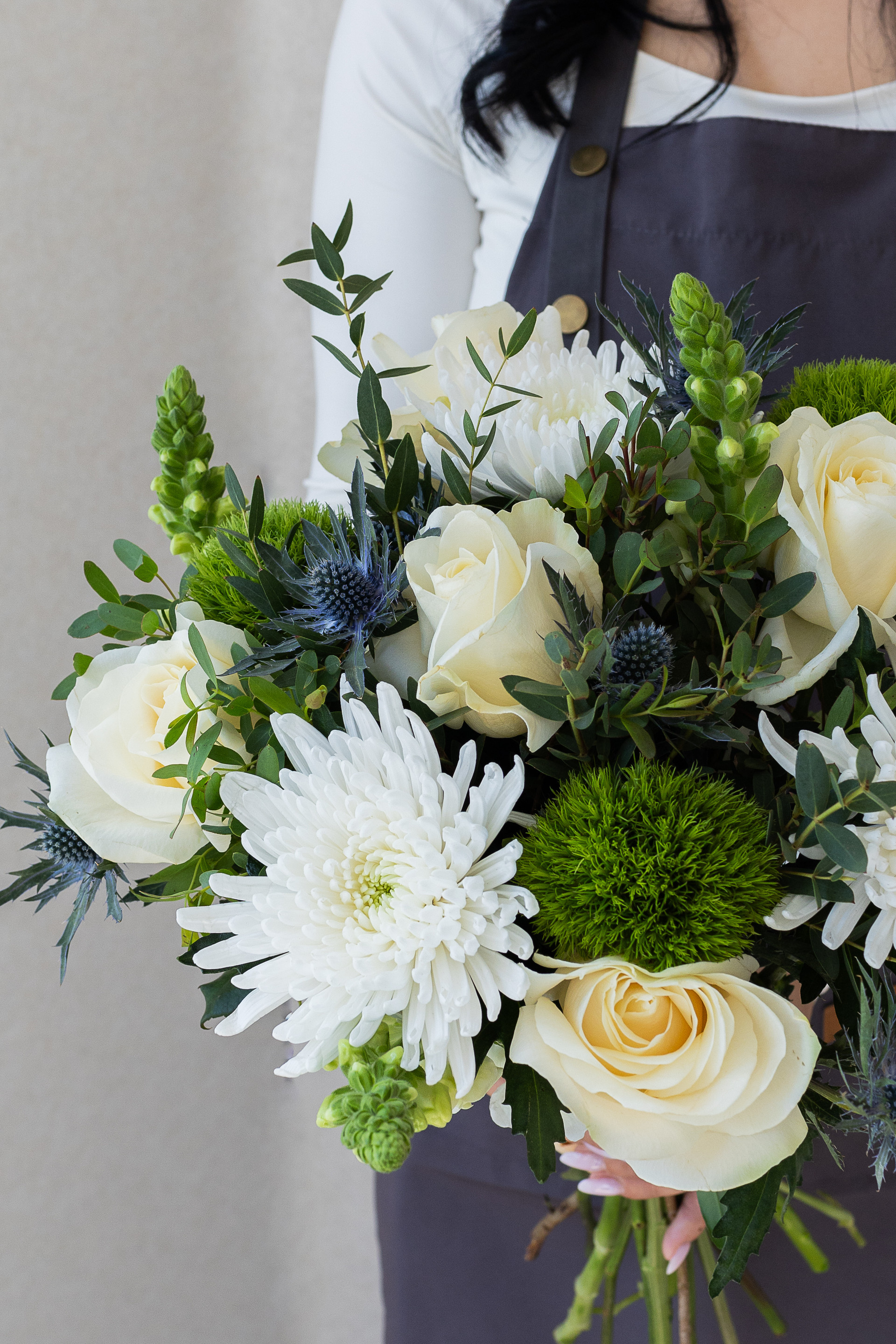 Close-up of ivory roses, white chrysanthemums, and green trick dianthus.
