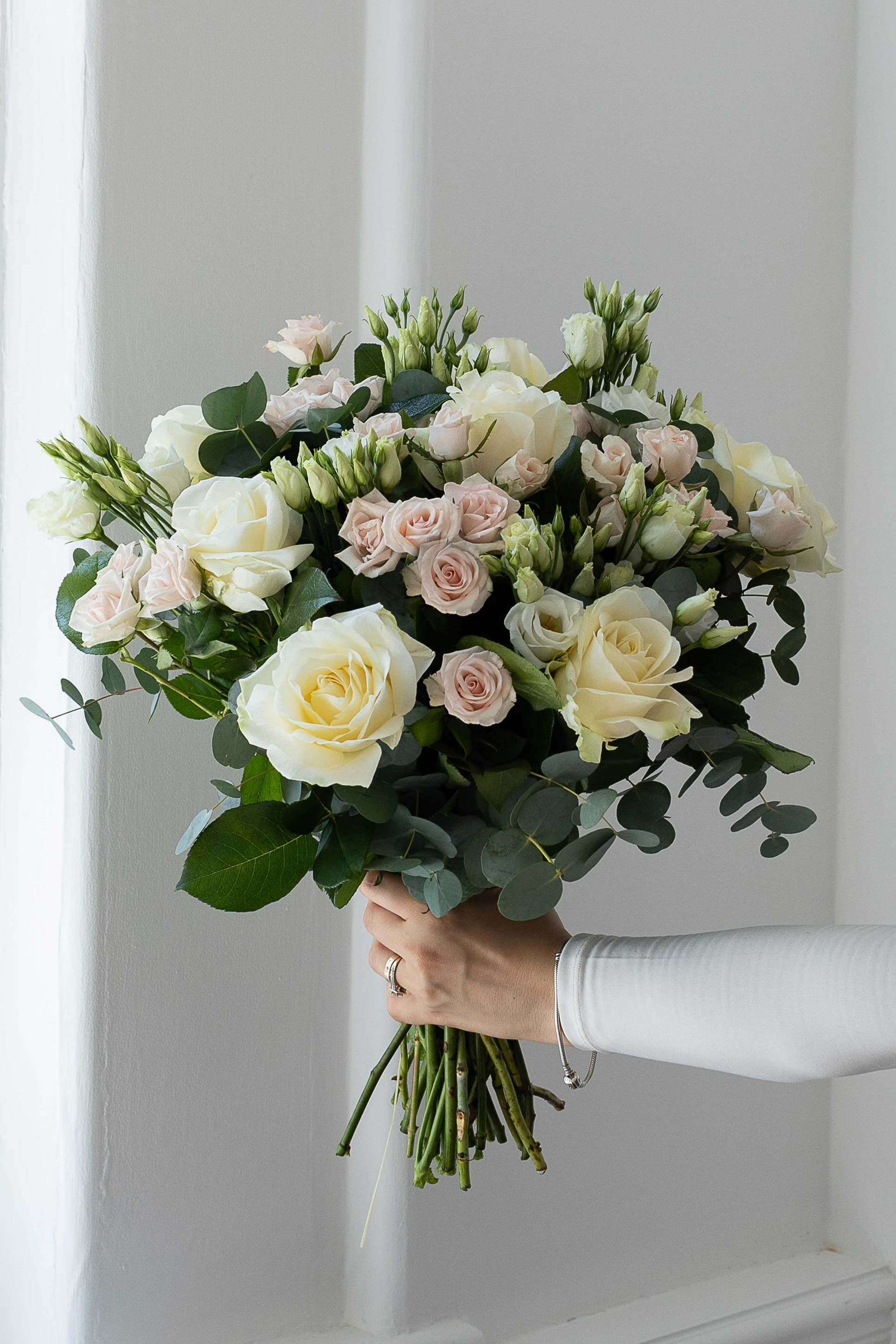 Ivory roses and blush spray roses with eucalyptus.