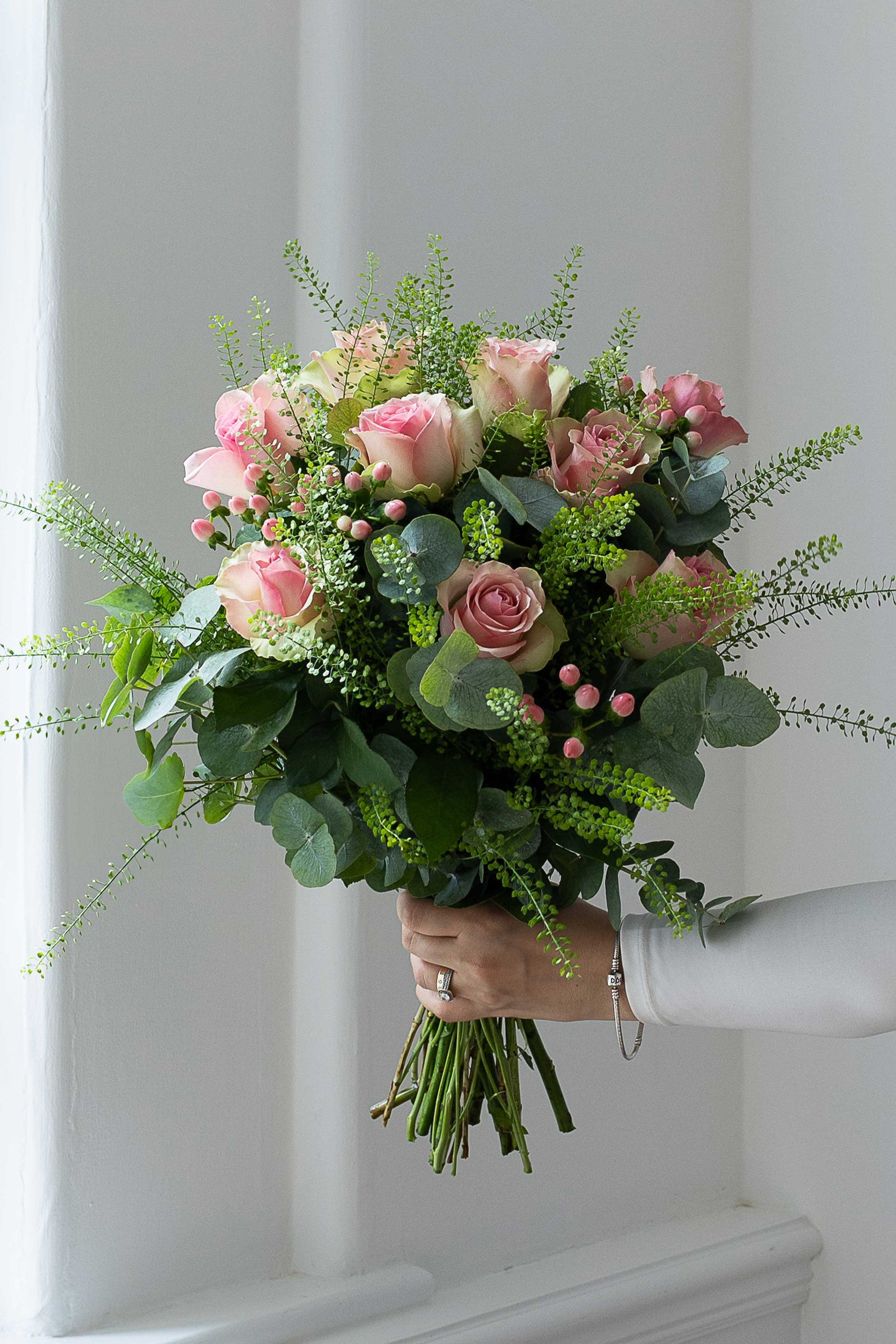 Pink rose bouquet with eucalyptus and pink berries.