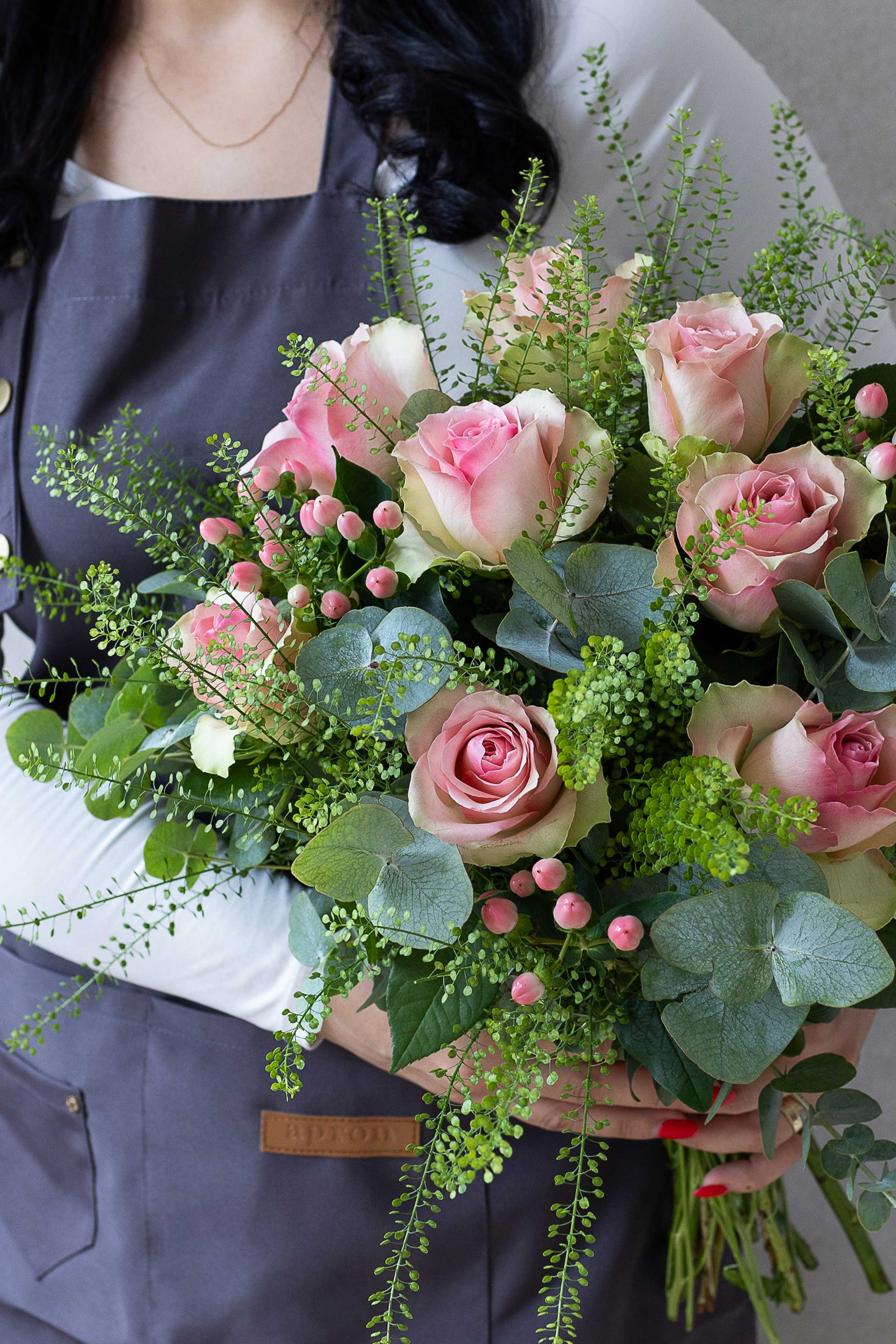 Blush pink roses with eucalyptus and pink berry accents.