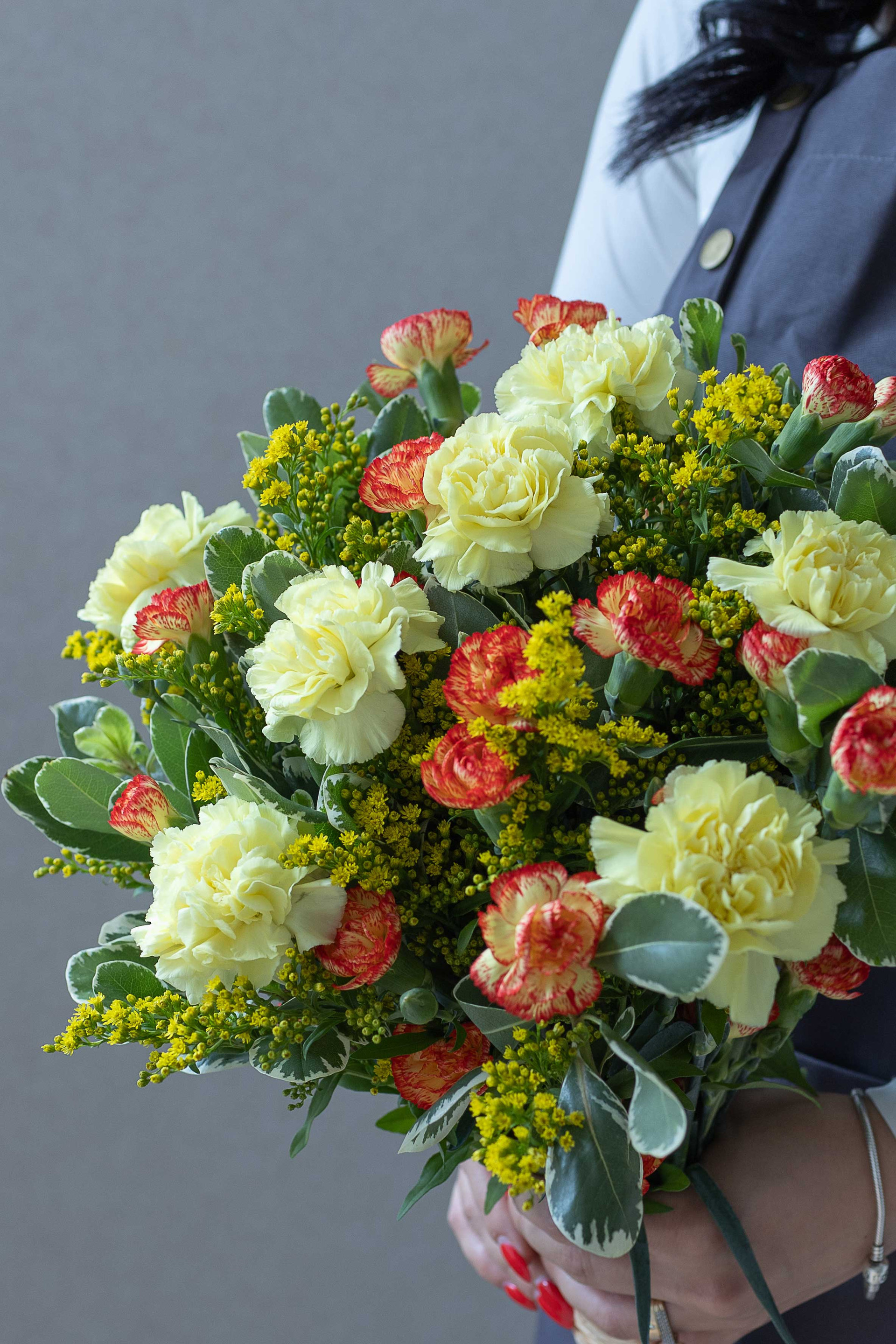 Close-up of yellow carnations, bicolour carnations, and yellow flowers.